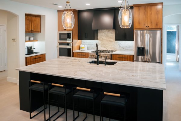 Flower Mound Modern Kitchen Remodel - This Flower Mound kitchen remodel brought together bold modern finishes with warm, livable details. We paired black slab-style cabinetry with warm walnut cabinetry, upgraded quartzite countertops and backsplash, and gold lighting accents to create contrast while keeping the space inviting.

Beyond the finishes, the remodel focused on everyday functionality with improved storage, durable materials, and a layout designed for cooking, gathering and entertaining.

Modern Blu managed the project from start to finish, bringing the cabinetry, stone, lighting and finishing details together into one cohesive space.