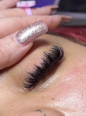 Wispy Lash Extensions - Wispy lashes are perfect if you're looking for a flirty look. The spikes placed throughout the set give the a fluttery appearance to achieve a soft dramatic look. This set uses long spikes set at even spaces throughout and volume fans all across, each on their own individual natural lash.