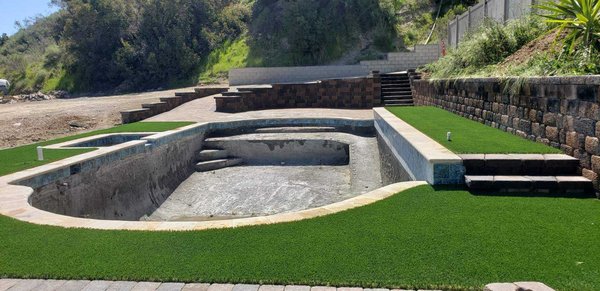 Re Build Of a Hidden Pool - This client moved into their new home not knowing there was a buried secret in the yard. Once the clients found out about their hidden gem they got to work.
Their pool builder started revamping the pool and we go to work on the surrounding areas. The client knew they wanted more Country Manor walls, steps and a ramp for the handicapped. We finished off the area with beautiful artificial turf.
We will move into designing and building the remaining areas around this hidden gem! Re Build Of a Hidden Pool - This client moved into their new home not knowing there was a buried secret in the yard. Once the clients found out about their hidden gem they got to work.
Their pool builder started revamping the pool and we go to work on the surrounding areas. The client knew they wanted more Country Manor walls, steps and a ramp for the handicapped. We finished off the area with beautiful artificial turf.
We will move into designing and building the remaining areas around this hidden gem!