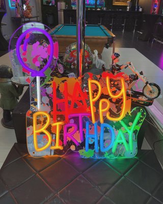 Party Place Signage - This custom "Happy Birthday" neon sign was crafted to add a vibrant, festive element to any birthday celebration. Designed and handcrafted by Good Neon, the sign features playful, colorful lettering and a neon balloon graphic. We printed a dynamic splatter paint design over acrylic, then installed neon lights over the top to create a striking and artistic effect.
Our process combines printed acrylic with bold neon lighting to create a unique look that stands out, making this piece a perfect addition to birthday parties and special events. We worked closely with the client to ensure the sign captured the celebratory spirit they were looking for.
At Good Neon, we offer a wide range of custom signage solutions to meet the diverse needs of our clients. Whether for business branding, special events, or personal projects, we specialize in designing and producing custom neon pieces that bring Party Place Signage - This custom "Happy Birthday" neon sign was crafted to add a vibrant, festive element to any birthday celebration. Designed and handcrafted by Good Neon, the sign features playful, colorful lettering and a neon balloon graphic. We printed a dynamic splatter paint design over acrylic, then installed neon lights over the top to create a striking and artistic effect.
Our process combines printed acrylic with bold neon lighting to create a unique look that stands out, making this piece a perfect addition to birthday parties and special events. We worked closely with the client to ensure the sign captured the celebratory spirit they were looking for.
At Good Neon, we offer a wide range of custom signage solutions to meet the diverse needs of our clients. Whether for business branding, special events, or personal projects, we specialize in designing and producing custom neon pieces that bring