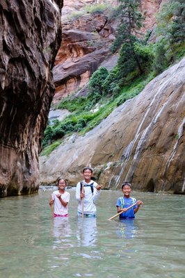 Hike The Narrows - Grandfather of desert slot canyons, The Zion Narrows has been rated one of the top ten hikes on Earth, and rightfully so. Leaving the pavement of the popular Riverside Walk, the Virgin River becomes the path, drawing you up into its towering walls and a sinuous path along river banks and knee-deep waters into the narrowest section of Wall Street where 18 million years of river erosion has cut 1500-foot walls into the earth. For many, hiking The Narrows is a life-changing experience. You can hike The Narrows, and we can help you! Hike The Narrows - Grandfather of desert slot canyons, The Zion Narrows has been rated one of the top ten hikes on Earth, and rightfully so. Leaving the pavement of the popular Riverside Walk, the Virgin River becomes the path, drawing you up into its towering walls and a sinuous path along river banks and knee-deep waters into the narrowest section of Wall Street where 18 million years of river erosion has cut 1500-foot walls into the earth. For many, hiking The Narrows is a life-changing experience. You can hike The Narrows, and we can help you!