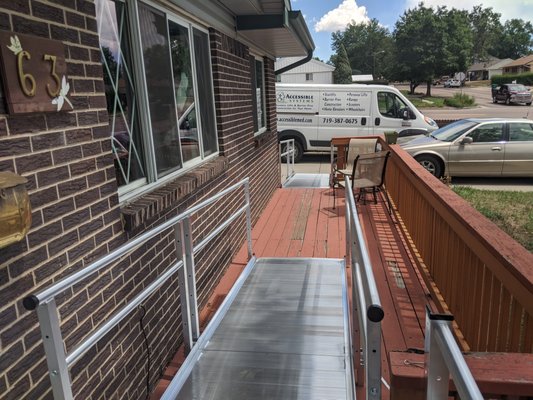 Modular Wheelchair Ramp on a Wooden Deck - This customer's daughter knew she had to do something to help her mom overcome accessibility barriers so that she can remain safe at home, but knew that funding a home modification seemed impossible much less living in an expensive assisted or independent living facility. Brothers Redevelopment helped secure funding and Accessible Systems installed a modular aluminum metal ramp that would grant Bertha easy and safe access into and out of her home. Minor modifications to the pre-existing wooden deck were made for the ramp. Modular Wheelchair Ramp on a Wooden Deck - This customer's daughter knew she had to do something to help her mom overcome accessibility barriers so that she can remain safe at home, but knew that funding a home modification seemed impossible much less living in an expensive assisted or independent living facility. Brothers Redevelopment helped secure funding and Accessible Systems installed a modular aluminum metal ramp that would grant Bertha easy and safe access into and out of her home. Minor modifications to the pre-existing wooden deck were made for the ramp.