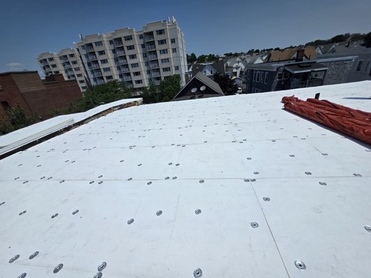 Flat Roof - Rubber roof replacement on a triple decker in Everett, MA. Hoisted materials onto the roof with a crane, stripped and done in 1 day.