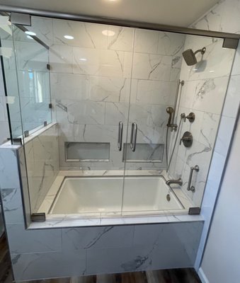 Contemporary Glass Shower/Tub Enclosure - We make sure to go over every aspect of your shower design to find what type of enclosure will work with your design and operational needs. This shower had a very classy contemporary feel to it so we decided to use flat, square hardware and a more frameless look. The homeowner also did not want to limit the opening size to the shower so we decided on a double set of doors instead of a door and a fixed panel. The result was this sleek glass enclosure in a matching brushed nickel finish. Contemporary Glass Shower/Tub Enclosure - We make sure to go over every aspect of your shower design to find what type of enclosure will work with your design and operational needs. This shower had a very classy contemporary feel to it so we decided to use flat, square hardware and a more frameless look. The homeowner also did not want to limit the opening size to the shower so we decided on a double set of doors instead of a door and a fixed panel. The result was this sleek glass enclosure in a matching brushed nickel finish.