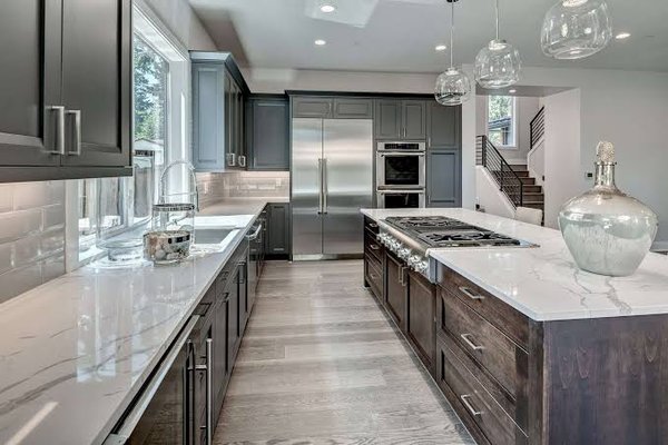 Kitchen Remodel - We removed a wall to open the space, designed new cabinets, client wanted a stain resistant white counter. We were able to re-use some appliances and hood fan to keep within client budget