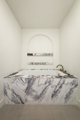 High-End Bespoke Master Bathroom Remodel - This area was an old storage area that was added to the master bathroom layout. With beautiful viola marble and fluted details, all to the organic tile used inside the master shower, and drop-in tub this space is timeless and the perfect retreat for a feel of luxury. The custom designed and built cabinetry is white rift oak that is functional and beautiful for years to come.