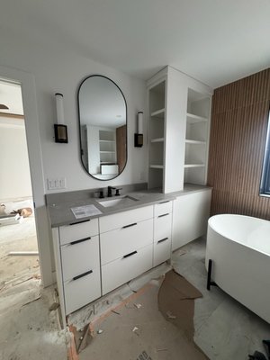 Master Bathroom New Construction - Modern look on a Master Bathroom in Minneapolis. One of our recent projects from fall of 2025. White flat panel cabinets and gray countertops with tile that looks like wood.