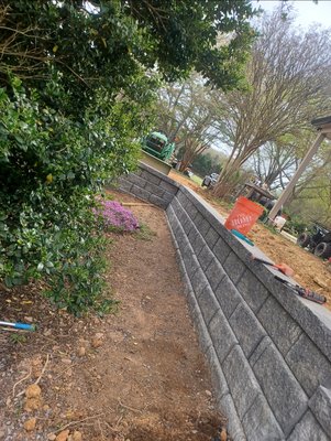 Retaining Walls & Garden Border Installation – Charlotte, NC - This exterior transformation included the construction of two custom retaining walls and a garden bed border, tailored to enhance both functionality and curb appeal. The first wall extends the yard’s footprint, creating additional level space ideal for outdoor living or recreation. The second wall was designed to support a dedicated planting area, perfect for shrubs and seasonal greenery—adding depth and softness to the landscape. In the front yard, we installed a clean and durable garden bed border to frame planting zones and highlight the home's façade. These features work together to stabilize the terrain, enrich the soil, and elevate the home’s visual presence. Retaining Walls & Garden Border Installation – Charlotte, NC - This exterior transformation included the construction of two custom retaining walls and a garden bed border, tailored to enhance both functionality and curb appeal. The first wall extends the yard’s footprint, creating additional level space ideal for outdoor living or recreation. The second wall was designed to support a dedicated planting area, perfect for shrubs and seasonal greenery—adding depth and softness to the landscape. In the front yard, we installed a clean and durable garden bed border to frame planting zones and highlight the home's façade. These features work together to stabilize the terrain, enrich the soil, and elevate the home’s visual presence.