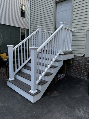 New backdoor entrance - Customer had old and unsafe stairs and landing on a back entrance of the property, new solid and safe stairs and landing was requested to build. 
New structure meets existing RI building code, has trex deck boards and vinyl handrails which makes is easy to maintain and would save nice look for a long time.