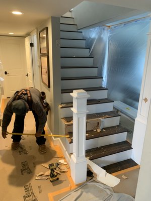 Custom Stairs - Customer's existing staircase had undersized treads too dangerous to walk down and risers that were uncomfortably tall. The customer and his family were also hitting their heads on the low ceiling walking down the stairs. To remedy these problems we redesigned the stairs to have wider treads and added and extra step to lower the riser height. We removed the low ceiling giving plenty of room to walk down.  We also replaced the dated painted wood beam and replaced it with a new white oak beam.