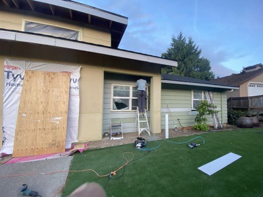 Home entrance siding installation in Bellevue, WA - Scope of Work:
- Site Preparation:
Inspect the existing exterior surface at the home entrance to ensure it is clean, dry, and free from any structural issues.
Perform any necessary repairs or adjustments to the underlying structure to ensure a solid foundation for the siding installation.
- Tyvek Home Wrap Installation:
Install Tyvek HomeWrap over the prepared surface to create a moisture barrier between the siding and the home's structure.
Ensure the home wrap is properly overlapped and sealed at all seams, corners, and edges to maximize its effectiveness in protecting against water infiltration.
Tape all seams and around windows and doors to prevent air and moisture penetration.
- Siding panel Installation:
Measure and cut James Hardie siding boards to fit the specific dimensions of the entrance area.
Install siding boards according to James Hardie’s installation guidelines, ensuring proper alignment, spacing, and secure attachment.
Pay close attention to the installation around windows, doors, and corners to ensure a seamless and weather-tight finish. Home entrance siding installation in Bellevue, WA - Scope of Work:
- Site Preparation:
Inspect the existing exterior surface at the home entrance to ensure it is clean, dry, and free from any structural issues.
Perform any necessary repairs or adjustments to the underlying structure to ensure a solid foundation for the siding installation.
- Tyvek Home Wrap Installation:
Install Tyvek HomeWrap over the prepared surface to create a moisture barrier between the siding and the home's structure.
Ensure the home wrap is properly overlapped and sealed at all seams, corners, and edges to maximize its effectiveness in protecting against water infiltration.
Tape all seams and around windows and doors to prevent air and moisture penetration.
- Siding panel Installation:
Measure and cut James Hardie siding boards to fit the specific dimensions of the entrance area.
Install siding boards according to James Hardie’s installation guidelines, ensuring proper alignment, spacing, and secure attachment.
Pay close attention to the installation around windows, doors, and corners to ensure a seamless and weather-tight finish.