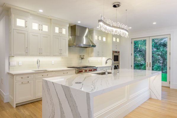 Custom Designed Kitchen in Flower Hill - New Contemporary Designed Kitchen installation in a brand new custom built residence in the heart of Flower Hill New York boasts a 12 feet long double sided Cambria Quartz countertop with 2.5 " Mitered edge, pop up touch control charging units and outlets, Instant Hot Water, Under-mounted stainless steel sink and custom designed and fabricated paneling. Custom Designed Kitchen in Flower Hill - New Contemporary Designed Kitchen installation in a brand new custom built residence in the heart of Flower Hill New York boasts a 12 feet long double sided Cambria Quartz countertop with 2.5 " Mitered edge, pop up touch control charging units and outlets, Instant Hot Water, Under-mounted stainless steel sink and custom designed and fabricated paneling.