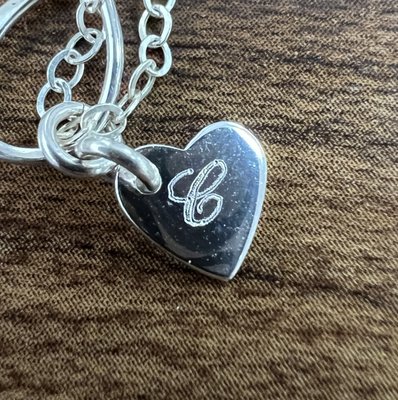 Custom Rotary Engraving on a Necklace Pendant for a Best Friend Gift - This project was a meaningful opportunity to help a customer create a special keepsake for her and her best friend. She brought in a tiny necklace pendant and entrusted us with the intricate task of engraving their initials—a heartfelt symbol of their enduring friendship.

We began by collaborating with the customer to select a font that balanced elegance and readability, ensuring it would work beautifully within the pendant's limited space. Engraving on such a small surface presented technical challenges, but our team was determined to deliver a flawless result.

Using precise rotary engraving techniques, we carefully inscribed the initials onto the pendant, taking extra care to maintain clarity and aesthetic appeal. The result was a delicate and beautifully engraved piece that carried immense sentimental value.

The customer was delighted with the outcome, and knowing we could help bring her vision to life made this project especially rewarding. It’s always a privilege to contribute to moments of connection and celebration, and this project exemplifies our dedication to craftsmanship and customer satisfaction.