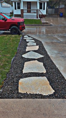 Walkway project - We took an area along a driveway that needed a walking path. Cut out the sod, dug down to desired grade, set base rock and compacted in lifts, set fine stone to rest stone pavers on, set large stone pavers, then finished with decorative stone and used rock glue to lock lose stone together.