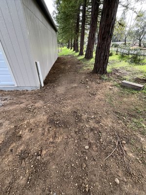 Graded next to shed - Cut down to install rock to prevent dirt on the road per city requirements. Graded and compacted next to shed. Graded next to shed - Cut down to install rock to prevent dirt on the road per city requirements. Graded and compacted next to shed.