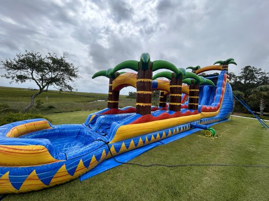 22' Tropical Inferno Water Slide Combo - The 22' Tropical Inferno brings resort-style fun straight to your backyard. A 22-foot climb, a fast wet drop, and a splash pool at the bottom - all wrapped in a tiki-and-palm design that looks as good in photos as it rides.

It's a go-to for summer birthdays, church and school field days, block parties, and neighborhood get-togethers across Summerville, Charleston, and the surrounding Lowcountry.

We handle the whole thing: delivery, setup on grass or a flat driveway, hookup to a standard garden hose and outdoor outlet, and takedown when the party wraps. Every unit is cleaned before it goes out.

Check your date and get a quote - call or message us and we'll get you on the calendar.