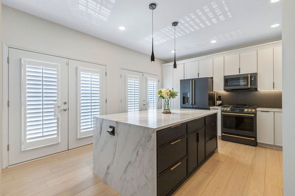 From Builder-Grade to White, Black & Brass Luxury - This project redefined the heart of the home through a bold yet timeless kitchen renovation. We began by completely removing the existing cabinets, counters, and flooring — making room for a reimagined layout that enhances both functionality and style.
The new design centers around a monumental quartz waterfall island, crafted to provide maximum prep space, storage, and seating. Custom cabinetry in matte white and jet black adds striking contrast, while brass hardware and integrated lighting deliver elegance and warmth.
We also upgraded the flooring to wide-plank engineered wood, bringing a cohesive and natural feel throughout. A full appliance suite in matte black — including a matching fridge, range, microwave, and hood — keeps the palette consistent and luxurious.
Additional upgrades include new recessed lighting, pendant fixtures, modernized plumbing, and USB/Pop-up outlets seamlessly integrated into the island and backsplash.
The result is a refined, functional kitchen with a high-end feel that blends everyday comfort with statement-making design. From Builder-Grade to White, Black & Brass Luxury - This project redefined the heart of the home through a bold yet timeless kitchen renovation. We began by completely removing the existing cabinets, counters, and flooring — making room for a reimagined layout that enhances both functionality and style.
The new design centers around a monumental quartz waterfall island, crafted to provide maximum prep space, storage, and seating. Custom cabinetry in matte white and jet black adds striking contrast, while brass hardware and integrated lighting deliver elegance and warmth.
We also upgraded the flooring to wide-plank engineered wood, bringing a cohesive and natural feel throughout. A full appliance suite in matte black — including a matching fridge, range, microwave, and hood — keeps the palette consistent and luxurious.
Additional upgrades include new recessed lighting, pendant fixtures, modernized plumbing, and USB/Pop-up outlets seamlessly integrated into the island and backsplash.
The result is a refined, functional kitchen with a high-end feel that blends everyday comfort with statement-making design.