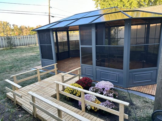 Sunroom - This project involved constructing a sturdy wooden ramp leading to a screened gazebo. The ramp features handrails for safety and accessibility, while the gazebo provides a stylish, functional outdoor space with durable flooring and screened walls for weather protection and comfort. The addition of decorative flowers enhances the aesthetic appeal, making the space a perfect spot for relaxation and gatherings. Sunroom - This project involved constructing a sturdy wooden ramp leading to a screened gazebo. The ramp features handrails for safety and accessibility, while the gazebo provides a stylish, functional outdoor space with durable flooring and screened walls for weather protection and comfort. The addition of decorative flowers enhances the aesthetic appeal, making the space a perfect spot for relaxation and gatherings.