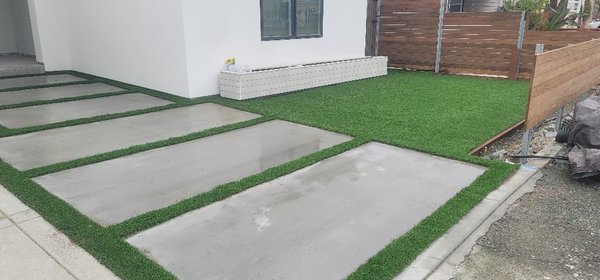 Turf install between cement! - Carefully done work on a home where turf is laid in between concrete slabs. A mix of fine sand weighs down the strips as well as short nails. The strips on the bottom portion blend directly into the main lawn and the top strips were all custom cuts making sure the lines were invisible. This is a small but highly skilled install to achieve a great look for a modern home. Turf install between cement! - Carefully done work on a home where turf is laid in between concrete slabs. A mix of fine sand weighs down the strips as well as short nails. The strips on the bottom portion blend directly into the main lawn and the top strips were all custom cuts making sure the lines were invisible. This is a small but highly skilled install to achieve a great look for a modern home.
