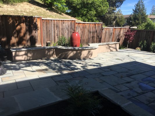 Connecticut blue flagstone patio with BBQ - This project was a complete backyard redesign, beginning with full demolition and site grading, followed by integrated drainage and infrastructure upgrades. The space was rebuilt with custom concrete retaining walls, raised planter boxes with built-in seating, and a bespoke masonry bench finished in Connecticut bluestone with a bullnose edge.
A large Connecticut bluestone patio in an Ashlar pattern was installed over a decomposed granite base, complemented by stabilized DG pathways. The project also included landscape lighting, electrical conduit for outlets and a water feature, a built-in outdoor countertop with grill area, and new fencing with gate and lattice details.
The landscape was finished with curated plantings, irrigation throughout, fresh mulch, timber steps for access, and a water feature that adds movement and ambiance.
The result is a refined, functional outdoor living space designed for both entertaining and everyday enjoyment. Connecticut blue flagstone patio with BBQ - This project was a complete backyard redesign, beginning with full demolition and site grading, followed by integrated drainage and infrastructure upgrades. The space was rebuilt with custom concrete retaining walls, raised planter boxes with built-in seating, and a bespoke masonry bench finished in Connecticut bluestone with a bullnose edge.
A large Connecticut bluestone patio in an Ashlar pattern was installed over a decomposed granite base, complemented by stabilized DG pathways. The project also included landscape lighting, electrical conduit for outlets and a water feature, a built-in outdoor countertop with grill area, and new fencing with gate and lattice details.
The landscape was finished with curated plantings, irrigation throughout, fresh mulch, timber steps for access, and a water feature that adds movement and ambiance.
The result is a refined, functional outdoor living space designed for both entertaining and everyday enjoyment.