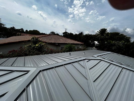Shingle to Metal Roof - Zeke's Roofing completed a full shingle-to-metal roof replacement for a Tampa Bay homeowner. The project included a complete tear-off of the existing asphalt shingles, inspection and repair of roof decking, and installation of a high-performance metal roofing system built for Florida weather. This upgrade provides longer lifespan, improved energy efficiency, and superior storm protection. Ideal for homeowners searching metal roof replacement or a trusted roofing contractor near me. Shingle to Metal Roof - Zeke's Roofing completed a full shingle-to-metal roof replacement for a Tampa Bay homeowner. The project included a complete tear-off of the existing asphalt shingles, inspection and repair of roof decking, and installation of a high-performance metal roofing system built for Florida weather. This upgrade provides longer lifespan, improved energy efficiency, and superior storm protection. Ideal for homeowners searching metal roof replacement or a trusted roofing contractor near me.