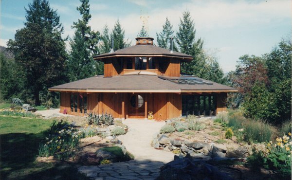 Hillside Octagon - This house is situated on the edge of a flat to take advantage of the slope in order to put another story below the main floor. The client requested an octagon shaped house with a cupola at the top. The house is totally off-the-grid. A field of solar panels lies to the south of the house, near the man-made, trout-stocked pond. A windmill and back-up natural gas 12kw generator provide power during the winter months There are vegetable gardens to the east of the house. A gray-water system waters the orchard and parts of the gardens. Hillside Octagon - This house is situated on the edge of a flat to take advantage of the slope in order to put another story below the main floor. The client requested an octagon shaped house with a cupola at the top. The house is totally off-the-grid. A field of solar panels lies to the south of the house, near the man-made, trout-stocked pond. A windmill and back-up natural gas 12kw generator provide power during the winter months There are vegetable gardens to the east of the house. A gray-water system waters the orchard and parts of the gardens.
