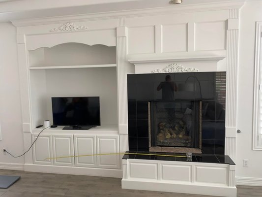Fireplace Remodel - This remodel was done on an older styled fireplace, the home owner just bought the house and wanted a newer, modern look. We tore out the old fireplace, framed in the new area, and added backing for the tv mount that they wanted. Once we installed the fireplace, we tiled the front of it and added hidden lights behind to make it stand out. We are very proud of this project and the home owners loved it.