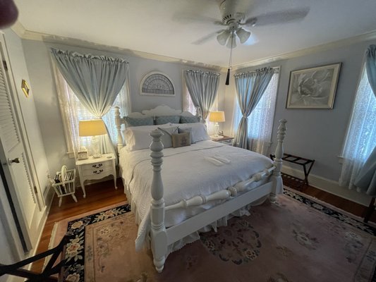 Inverno Room - This heavenly room with a fireplace, reminiscent of the cool colors of "Winter" allows you to escape into tranquility with a softness while you rest. Lavishly decorated with white-wash furnishings and a king-size poster bed, complimenting the peaceful decor in this room. The private shower has yellow tile and Waverly white wallpaper with blue ribbons filling the room.
Amenities include a complimentary refillable water bottle and slippers for two, bathrobes, cable ready TV, alarm clock with outlets and USB ports, and high speed internet.
Onsite parking allows for a casual two block walk to Mount Dora Historic District. Inverno Room - This heavenly room with a fireplace, reminiscent of the cool colors of "Winter" allows you to escape into tranquility with a softness while you rest. Lavishly decorated with white-wash furnishings and a king-size poster bed, complimenting the peaceful decor in this room. The private shower has yellow tile and Waverly white wallpaper with blue ribbons filling the room.
Amenities include a complimentary refillable water bottle and slippers for two, bathrobes, cable ready TV, alarm clock with outlets and USB ports, and high speed internet.
Onsite parking allows for a casual two block walk to Mount Dora Historic District.