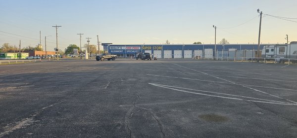 Bosley Tires parking lot makeover. - This sealcoating project was done at a reputable tire store in Wichita, KS. The lot was a perfect candidate for crack filling, sealcoating, and striping. Bosley Tires parking lot makeover. - This sealcoating project was done at a reputable tire store in Wichita, KS. The lot was a perfect candidate for crack filling, sealcoating, and striping.