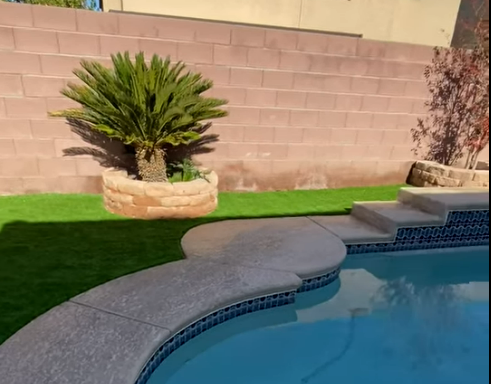 Pool with limited space. - Per our recommendation; we installed artificial grass, along adding concrete wall blocks around plants high enough to use as a sitting area, since the backyard was limited in space. We also installed concrete on the side of the house to make it more easily accessible.