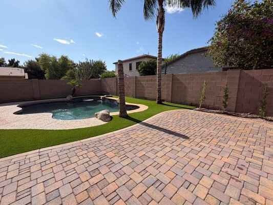 A Backyard Worth Diving Into - This beautiful poolside renovation combines lush artificial turf, a spacious paver patio, and a matching walkway that ties the entire design together. The finished layout feels open, elegant, and perfectly suited for relaxing, entertaining, and enjoying the outdoors year-round. A Backyard Worth Diving Into - This beautiful poolside renovation combines lush artificial turf, a spacious paver patio, and a matching walkway that ties the entire design together. The finished layout feels open, elegant, and perfectly suited for relaxing, entertaining, and enjoying the outdoors year-round.