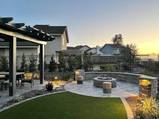 Scripps Ranch Design + Build - Complete Backyard landscape design and build including paver patio, retaining walls to extend the backyard, firepit, artificial turf, masonry free standing walls, metal fencing around property, alumawood patio cover, flagstone patio and paths, low voltage lighting, low maintenance landscaping, and custom metal gate.