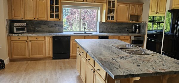 Stunning Ijen Blue Leathered Quartzite Granite Countertops - This kitchen countertop remodel project encompassed the complete removal of the existing countertops and backsplashes, followed by the meticulous installation of distinctive Ijen Blue Leathered Quartzite Granite, creating a stunning and modern upgrade for the kitchen space.