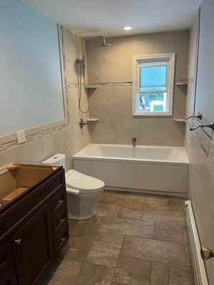 bathroom remodel mount sinai - this bathroom was a total gut down th the studs , toilet and tub and plumbing were relocated , single sink was made into double sink , tile on walls , floor and shower area ,sheet rock, spackle and paint , recessed lighting and heat lamp installed bathroom remodel mount sinai - this bathroom was a total gut down th the studs , toilet and tub and plumbing were relocated , single sink was made into double sink , tile on walls , floor and shower area ,sheet rock, spackle and paint , recessed lighting and heat lamp installed