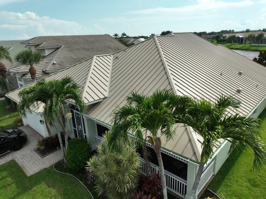 Mechanical Seam Metal Roof (Port St. Lucie, FL) - This Port St. Lucie homeowner was ready to move on from their aging concrete tile roof—but they weren’t willing to compromise on looks or performance. They wanted the highest possible wind resistance, a sleek, modern aesthetic, and a roof built to last. That’s exactly what we delivered.
We replaced their old roof with a 1.5-inch mechanical seam standing seam system in 24-gauge Kynar-coated steel, finished in Sierra Tan for a clean, refined appearance that nods to the classic style of concrete tile, while updating the home’s curb appeal with a more modern edge.
Beneath the metal panels, we installed a high-temp peel-and-stick underlayment, providing superior waterproofing and thermal protection. This double-strength system is built to stand up to Florida’s toughest weather, including hurricane-force winds — in fact, mechanical seam roofs are the most wind-resistant systems you can put on a home.
Every detail was crafted for performance and precision. This project was completed in less than a week by our expert crew, and it’s backed by our 15-year workmanship warranty. The homeowner also enrolled in our exclusive Rhin-O-Tuff Maintenance Program, which includes inspections and resealing every three years at no additional cost — keeping their new roof in peak condition for years to come.
This is what modern Florida roofing looks like: strong, smart, and Rhino Tough. Mechanical Seam Metal Roof (Port St. Lucie, FL) - This Port St. Lucie homeowner was ready to move on from their aging concrete tile roof—but they weren’t willing to compromise on looks or performance. They wanted the highest possible wind resistance, a sleek, modern aesthetic, and a roof built to last. That’s exactly what we delivered.
We replaced their old roof with a 1.5-inch mechanical seam standing seam system in 24-gauge Kynar-coated steel, finished in Sierra Tan for a clean, refined appearance that nods to the classic style of concrete tile, while updating the home’s curb appeal with a more modern edge.
Beneath the metal panels, we installed a high-temp peel-and-stick underlayment, providing superior waterproofing and thermal protection. This double-strength system is built to stand up to Florida’s toughest weather, including hurricane-force winds — in fact, mechanical seam roofs are the most wind-resistant systems you can put on a home.
Every detail was crafted for performance and precision. This project was completed in less than a week by our expert crew, and it’s backed by our 15-year workmanship warranty. The homeowner also enrolled in our exclusive Rhin-O-Tuff Maintenance Program, which includes inspections and resealing every three years at no additional cost — keeping their new roof in peak condition for years to come.
This is what modern Florida roofing looks like: strong, smart, and Rhino Tough.
