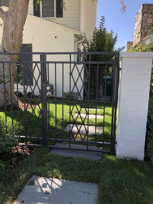 Custom Wrought Iron Fence & Gates – Hancock Park - This project features a fully custom wrought iron fence and matching gates with a diamond lattice design. Built for both security and elegance, the system includes a pedestrian entry, driveway gate, and perimeter fencing that complements the home’s classic architecture.