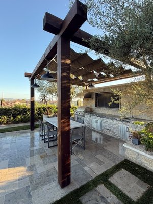 Custom Timber Pergola & Shade Installation in Yorba Linda, CA - We recently completed a custom wood pergola installation for a backyard outdoor living space in Yorba Linda, CA. This project included complete demolition and removal of the existing pergola, site preparation, construction of a new heavy timber pergola, restoration of the existing pendant lighting, and installation of a retractable shade canopy to create a comfortable and functional outdoor entertaining area.

The new pergola was built using premium timber and finished with the traditional Shou Sugi Ban wood charring technique, enhancing the natural wood grain while providing a unique, modern appearance. To maximize durability, every wood surface was sealed with a high-quality protective coating designed to withstand California sun, moisture, and everyday outdoor use.

As part of the project, we carefully restored the existing pendant lights by cleaning, rewiring, refinishing, and applying a protective finish before reinstalling them beneath the new pergola. We also installed a retractable shade canopy that provides flexible sun protection while seamlessly connecting the outdoor dining area with the outdoor kitchen.

This backyard renovation transformed the space into a beautiful, durable, and functional outdoor living area designed for relaxing and entertaining. Whether you need pergola installation, exterior carpentry, outdoor renovations, or custom backyard improvements, HomeWise Repairs delivers quality craftsmanship with attention to every detail.
