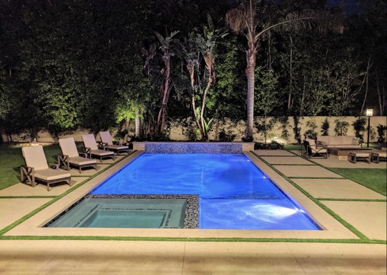 Encino Project - This client had an outdated pool and wanted a fresh, modern upgrade—and we delivered! We transformed the old pool and worn-out yard into a sleek, luxurious space featuring a linear pool, a timeless fire pit, and a fully customized outdoor kitchen. On the back end of the pool, we added a stunning tiled wall with a unique water feature, showcasing a beautiful spillway for an elegant touch.