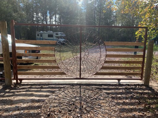 Custom welded iron gate - This project was a fun one! A customer gave us the emblem pieces in the middle and we designed this beautiful gate for them. We had the emblem welded to a frame and built horizontal boarding around it. It was then installed on a sliding track with an automatic gate opener. If you’re looking for something unique, give us a call!