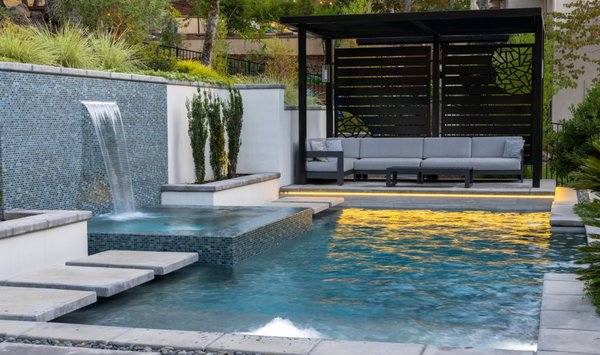 Rocklin Modern Outdoor Retreat - What began as an outdated rock pool and plain patio was completely reimagined into a modern outdoor retreat. The transformation features a sleek pool and spa with waterfall, custom outdoor kitchen, and multiple lounge areas with architectural shade structures. Designed for both style and function, this backyard is now a luxury escape perfect for entertaining and relaxing. Rocklin Modern Outdoor Retreat - What began as an outdated rock pool and plain patio was completely reimagined into a modern outdoor retreat. The transformation features a sleek pool and spa with waterfall, custom outdoor kitchen, and multiple lounge areas with architectural shade structures. Designed for both style and function, this backyard is now a luxury escape perfect for entertaining and relaxing.