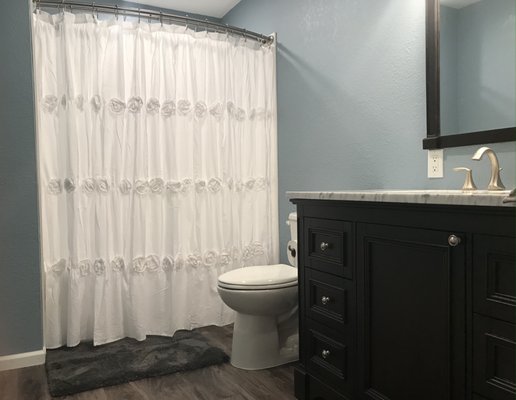 Small Bathroom Remodel Project - This small bathroom renovation was completed in just 2 days. First all of the fixtures and old flooring were removed without damaging the existing sheetrock. Next the concrete floor was opened up, the toilet waste piping was moved 8" and the floor was re-cemented. Moving the toilet away from the tub made the small space feel larger. Then the new tub and shower wall unit was installed. Finally the walls were painted and the new flooring, toilet, vanity, sink and mirror were installed. This project also used lighting and a curved shower curtain rod to make the small space feel roomier and more inviting. If you are thinking of remodeling your bathroom give us a call we can help. Small Bathroom Remodel Project - This small bathroom renovation was completed in just 2 days. First all of the fixtures and old flooring were removed without damaging the existing sheetrock. Next the concrete floor was opened up, the toilet waste piping was moved 8" and the floor was re-cemented. Moving the toilet away from the tub made the small space feel larger. Then the new tub and shower wall unit was installed. Finally the walls were painted and the new flooring, toilet, vanity, sink and mirror were installed. This project also used lighting and a curved shower curtain rod to make the small space feel roomier and more inviting. If you are thinking of remodeling your bathroom give us a call we can help.