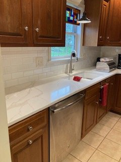 Countertop and backsplash replacement - On this project we replaced a worn Formica countertop with a new quartz countertop and undermount sink, installed a new tile backsplash, installed a new faucet and updated the electrical outlets and switches. Countertop and backsplash replacement - On this project we replaced a worn Formica countertop with a new quartz countertop and undermount sink, installed a new tile backsplash, installed a new faucet and updated the electrical outlets and switches.