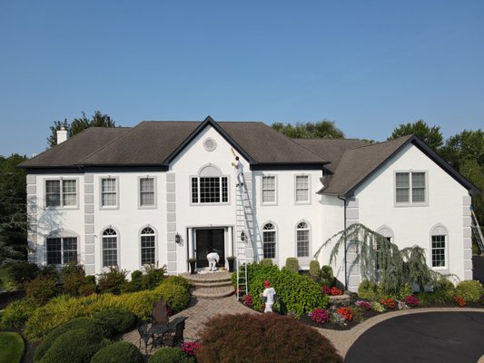 Exterior Painting - Moorestown, NJ - The transformation of the magnificent mansion owned by a retired NBA player in Moorestown, NJ was a testament to the collaborative spirit at Dambrak Painting. Working closely with the homeowner and his wife, we embarked on an exciting journey to redefine their exterior with a color palette that exuded both uniqueness and timelessness. Departing from convention, we opted for a bold yet elegant choice by adorning the trim in a striking dark gray, perfectly complementing the classic off-white hue chosen for the main body of the house. This harmonious blend of tradition and innovation not only revitalized the mansion but also encapsulated the homeowners' distinctive style, creating a visual masterpiece that stood as a testament to the fusion of creative vision and skilled craftsmanship. Exterior Painting - Moorestown, NJ - The transformation of the magnificent mansion owned by a retired NBA player in Moorestown, NJ was a testament to the collaborative spirit at Dambrak Painting. Working closely with the homeowner and his wife, we embarked on an exciting journey to redefine their exterior with a color palette that exuded both uniqueness and timelessness. Departing from convention, we opted for a bold yet elegant choice by adorning the trim in a striking dark gray, perfectly complementing the classic off-white hue chosen for the main body of the house. This harmonious blend of tradition and innovation not only revitalized the mansion but also encapsulated the homeowners' distinctive style, creating a visual masterpiece that stood as a testament to the fusion of creative vision and skilled craftsmanship.