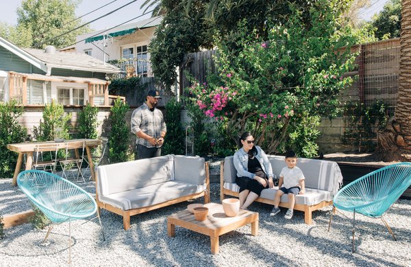 Backyard Retreat + Farm to Table - This backyard remodel was inspired by our clients travel and love of farm to table cooking. It has an organic and inviting feel with may distinct but cohesive areas to gather and socialize. Two custom raised vegetable boxes were installed. Surrounding the Date Palm is a raised  planter box that doubles as extra seating space. Two levels were created with a single step, a outdoor dining area and lounge space. Lighting creates a warm and safe space to transition from day to night and extend the patios use. A custom trough imported from Belgium adds interest, and tranquility.