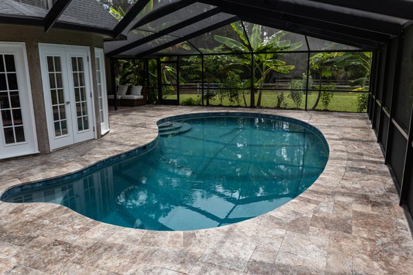 Pool Remodel in Spring Hill - In this full pool remodel, we installed a new travertine pool deck, tile, coping, and new pebbletec interior finish.