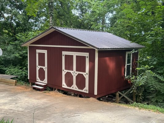 Custom Elevated Outbuilding — Louisville, Tennessee - This custom 16×20 outbuilding was designed and built specifically for a challenging, severely sloped property in Louisville, Tennessee. Rather than allowing the steep grade to limit the design, Koproski & Vaughan LLC developed an elevated structural system that allowed the finished building to remain level while working naturally with the existing terrain.

The structure is supported by concrete footings and substantial 6×6 pressure-treated posts, with portions of the building elevated approximately 5-8 feet above the surrounding grade. Custom-built roof trusses were fabricated specifically for the project, allowing us to achieve the desired proportions and roof design while accommodating the unique site conditions.

Inside, the building features a durable pressure-treated floor system with 2×8 framing and Advantech subflooring. The exterior was finished with LP SmartSide panel siding, custom trim details, and an exposed-fastener metal roof, creating a classic aesthetic with materials selected for long-term durability.

Every aspect of the project—from the elevated foundation and structural framing to the custom trusses and detailed exterior finishes—was built with the property and the client's vision in mind.

This project reflects the kind of custom residential construction Koproski & Vaughan LLC is built for: challenging sites, unique designs, and craftsmanship where the details matter. As a fully licensed and insured Tennessee general contractor, we serve Knoxville and communities throughout East Tennessee.