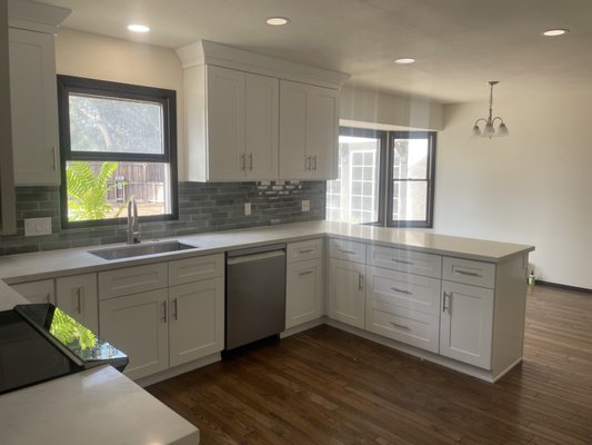 Simple. Beautiful. White Shaker and Quartz Kitchen Remodel - What a great White Shaker Kitchen! Pull out trash cabinet, spice rack, roll-out trays, and I love that large crown molding that really pops!