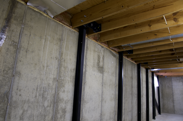 Basement Wall Stabilized with Steel Bracing System - This basement wall was reinforced using a professionally installed steel bracing system to address bowing and structural movement. Over time, pressure from surrounding soil can cause walls to shift or lean inward, compromising the integrity of the home. These heavy-duty steel beams were securely anchored to the framing above and the floor below to permanently stabilize the wall. The result is a stronger, safer foundation with a clean, low-profile solution that helps prevent further movement and provides long-term peace of mind.