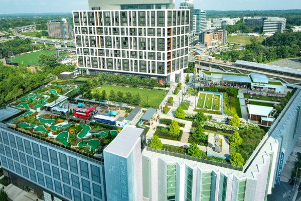 The Perch at Capital One Center - We’ve taken the guesswork out of what to do while you’re here with us in Tysons. Welcome to your village green in the sky, set atop Capital One Hall and connected to The Watermark Hotel. Play lawn games and mini golf, sip a frothy frozen cocktail, feast on street food, and soak up the convivial atmosphere. The Perch at Capital One Center - We’ve taken the guesswork out of what to do while you’re here with us in Tysons. Welcome to your village green in the sky, set atop Capital One Hall and connected to The Watermark Hotel. Play lawn games and mini golf, sip a frothy frozen cocktail, feast on street food, and soak up the convivial atmosphere.