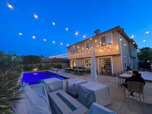 Low voltage Bistro lights installation over pool - We are very happy with the results of this custom bistro lights  installation, we installed 8 wooden post to be able to create this stunning design of lights crossing each other.